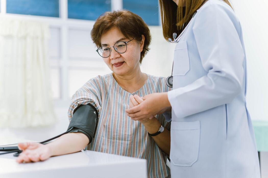 close-up-doctor-checking-senior-patient-blood-pressure-health-care-free-photo